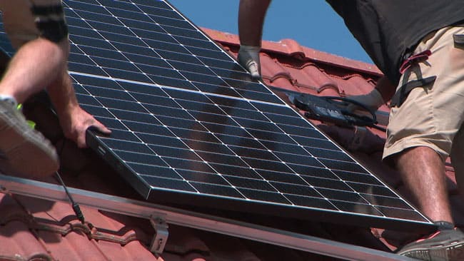 photo de poseur de panneaux photovoltaiques sur toiture de la société