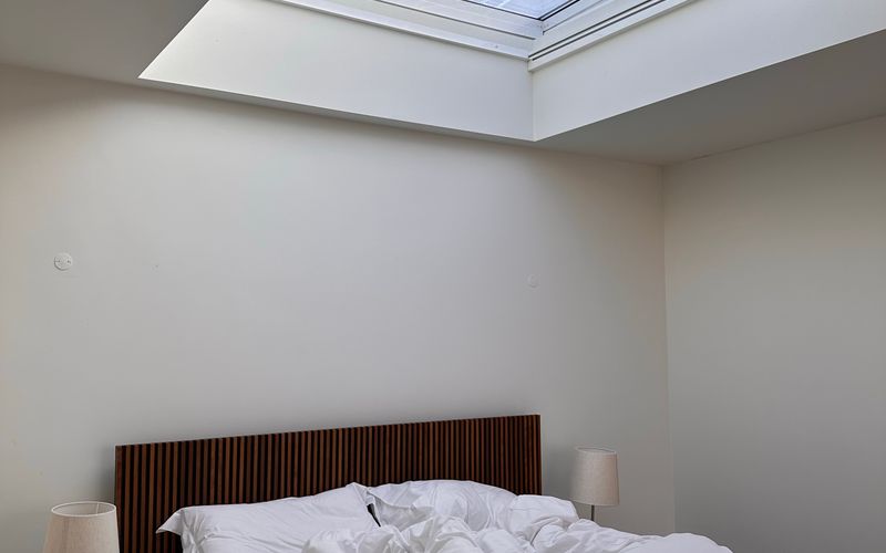 Chambre aménagée sous les combles, éclairée par une fenêtre de toit