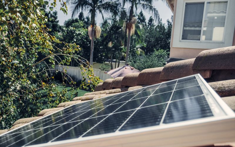 Gros plan d'un panneau solaire posé sur un toit en tuiles