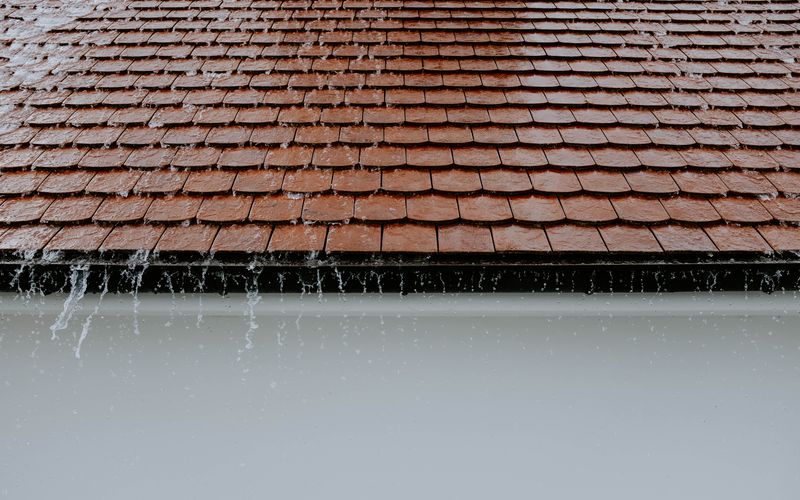 Eau de pluie ruisselant sur des tuiles de toiture