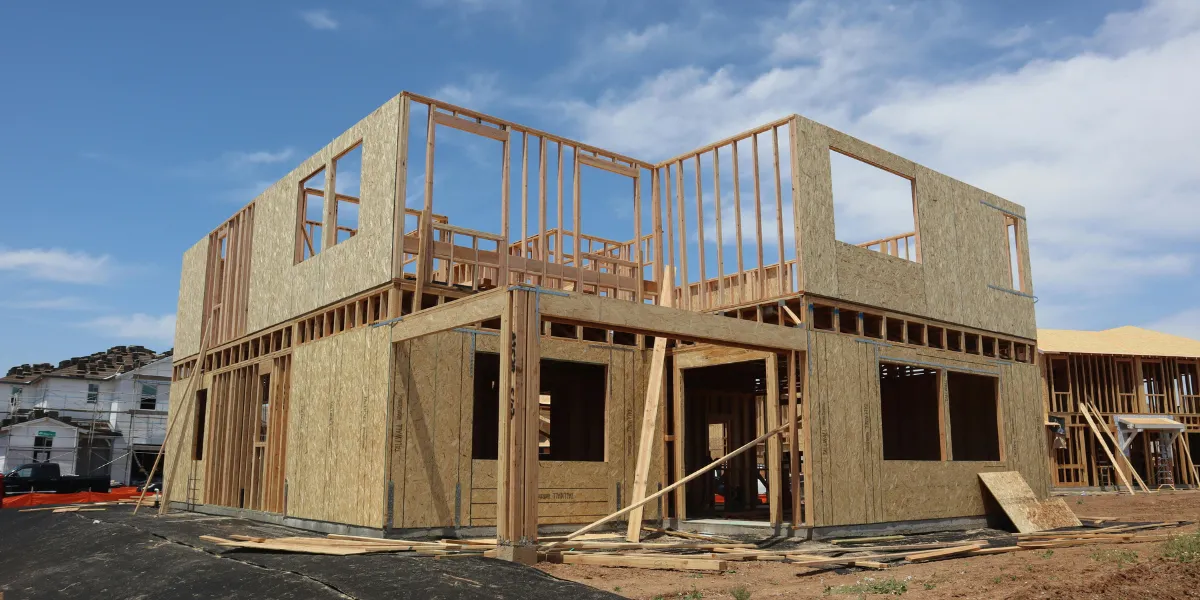 Maison individuelle en construction au stade du gros œuvre avec charpente posée