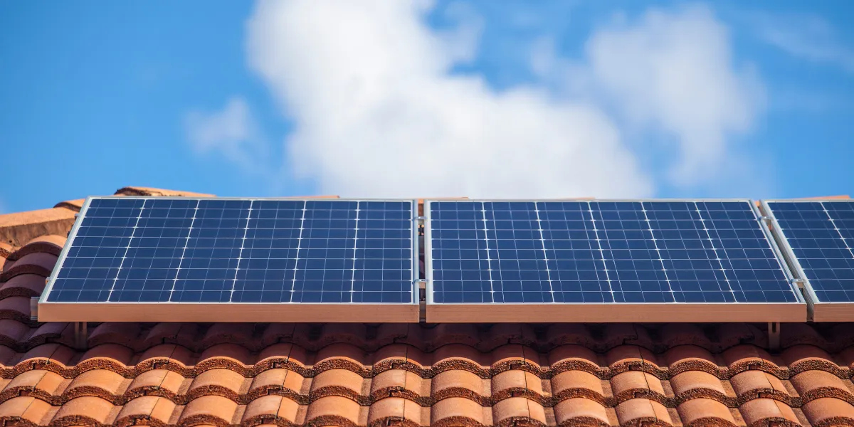 Deux toitures côte à côte, l'une équipée de panneaux solaires, l'autre de tuiles solaires intégrées
