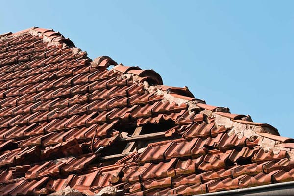 Tuiles cassées sur une toiture de maison avant rénovation