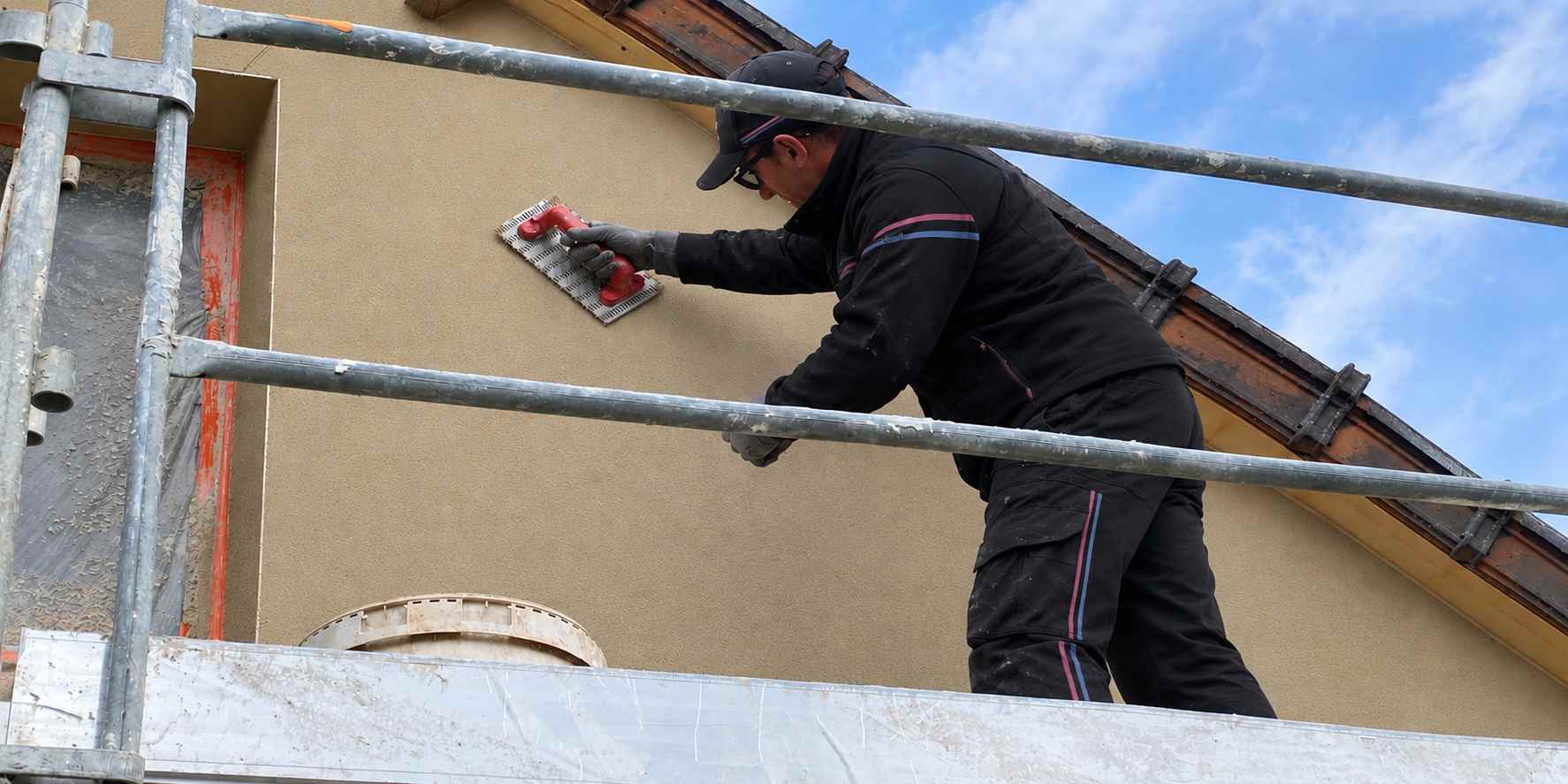 Ouvrier CHS Heaven Energy réalisant le ravalement de façade d'une maison