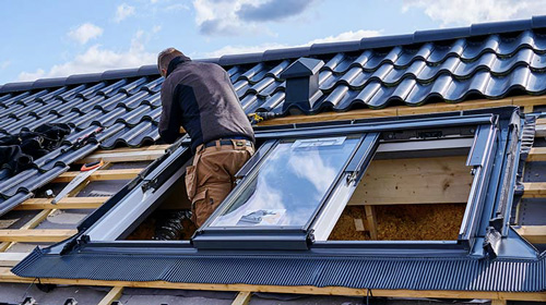 Ouvrier posant une fenêtre de toit Velux à Brétigny-sur-Orge
